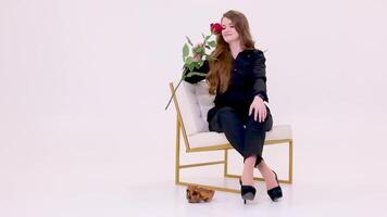 Frau Sitzung auf ein golden Weiß Stuhl riechen ein Rose Rose fallen auf das Schädel von ihr ehemalige Liebhaber hat verloren Liebe Mord schick tückisch Dame Mädchen auf Weiß Hintergrund hoch Absätze europäisch video