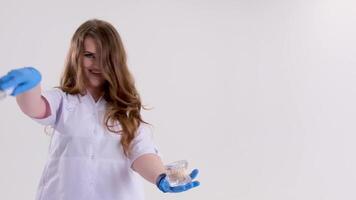 doctor with a magic wand in blue latex gloves loose hair conjures up a treatment. invents treatments advertisements for tasty supplements medicines nutritional supplements ointments creams video