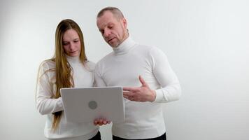 school office man and woman with laptop laughing rejoicing at new project completion of transaction successful online purchase white background white clothes smile girl looking at computer man to side video