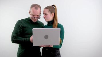 daughter teaches father man in glasses sliding down nose looks in surprise at laptop screen monitor wrong embarrassment embarrassment inconvenience man in a dark green golf listens gets older video
