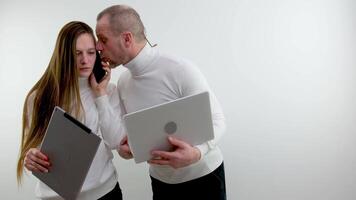 tableta-portátil teléfono llamada calculando fuera algunos tipo de problema hablando en teléfono hombre y mujer escuchando blanco suéteres en un blanco antecedentes en línea entrega estudiar en línea lecciones largo pelo profesor estudiante video