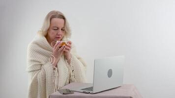 mulher bebidas chá chamadas em a telefone parece às a computador portátil cortada costas traseiro Visão do expectante mãe sentado usando pc computador portátil enquanto falando com inteligente doutor. ela mostrando gravidez teste dentro Câmera video