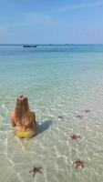caucasien femme relaxant dans tropical mer avec étoile de mer, phu quoc île, vietnam video