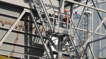 An engineer climbs up metal structures at a construction site. video