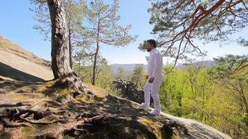 un hombre en blanco ropa sube arriba. turista fiesta caminata a el cima. video