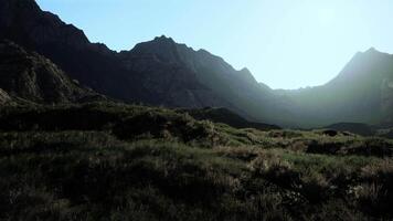 The sun shines on the mountains in the valley. mountain sunset video