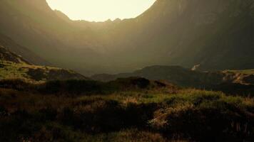 de zon schijnt helder door de bergen. berg zonsondergang video