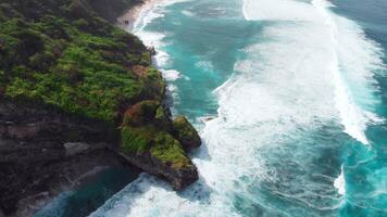 naturskön sten klippa och blå hav med surfing vågor. Drönare se video
