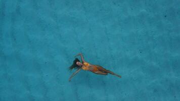 Frau im Bikini schwimmen und chillen im Blau Meer. Drohne oben Nieder Aussicht video