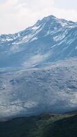 Antenne über dem Tal mit schneebedeckten Bergen in der Ferne video