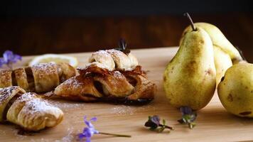Sweet pastries, puff pastries with pears, on a wooden table video
