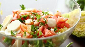 frisch Gemüse Salat, Kohl, Tomaten im ein Schüssel auf ein hölzern Tabelle video