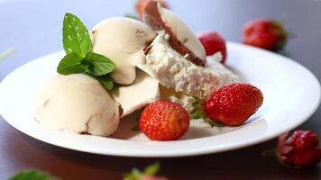 frisch organisch Hütte Käse mit Erdbeeren und Eis Sahne im ein Teller auf ein hölzern Tabelle video
