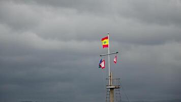 drie vlaggen vliegend Aan mast onder bewolkt lucht video