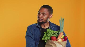 jung Person bleiben im Linie beim das lokal Bauern Markt und reden zu Kunden, befürworten zum Null Abfall nachhaltig Lebensstil. vegan Kerl unterstützen lokal Landwirtschaft, gesund Essen. Kamera a. video