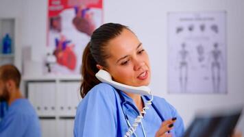 Close up of assistant answering phone checking the result of patient x-ray and diagnosing him. Healthcare physician in medicine uniform, receptionist doctor nurse helping with telephone concultation video