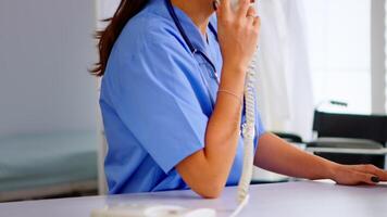 médical réceptionniste répondre téléphone appels de patient dans hôpital vérification rendez-vous. soins de santé médecin dans médicament uniforme, médecin infirmière assistant portion avec télésanté la communication video