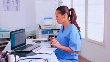 Nurse checking x-ray result, reading patients list, taking notes in clipboard holding radiography. Medical physician in medicine uniform writing list of consulted, diagnosed patients, making research. video