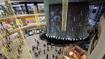 Dubai - Verenigde Arabisch emiraten 01.05.2024 waterval binnenplaats Bij Dubai winkelcentrum, verbijsterend waterval binnenplaats binnen Dubai winkelcentrum, versierd met verlichte decoraties en omringd door winkels video