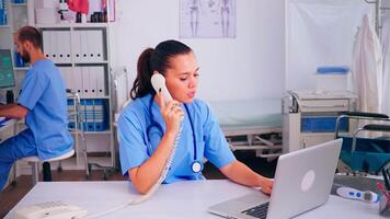 cirujano asistente que se discute con paciente en teléfono desde hospital acerca de diagnóstico, masculino enfermero trabajando en antecedentes. cuidado de la salud médico, recepcionista médico Ayudar con telesalud comunicación video