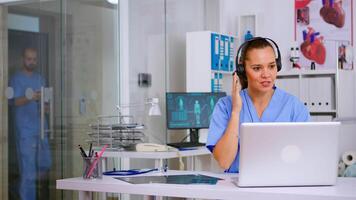 Specialist health practitioner prescribing treatments for patients during telehealth using headset, answering calls. Healthcare physician in medicine uniform, doctor nurse helping with appointment video