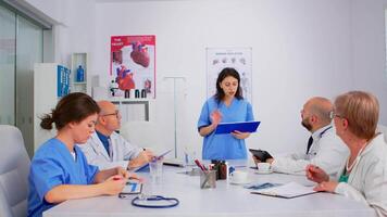 attentif médical équipe discuter médicament problèmes, médecins avec tablette PC et presse-papiers travail dans réunion hôpital bureau. réflexion des idées, médecins diagnostic en utilisant moderne La technologie video