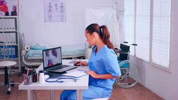 Group of assistents working in hospital office, analysing digital heart presentation and body scan. Medical physician in medicine uniform writing list of consulted, diagnosed patients, making research. video