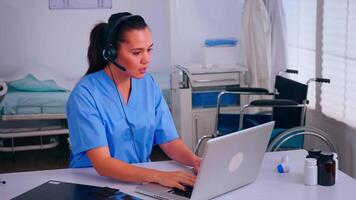 Assistant offering medical online services using headphone answering calls, making appointments. hospital call center Healthcare physician in medicine clinic, receptionist doctor nurse helping with concultation video