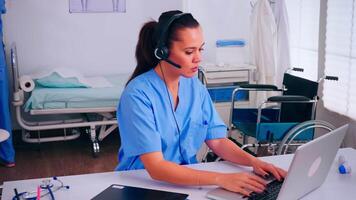 Receptionist, operator speaking online with patients using headphone helping people with health problems sitting in hospital workplace. Healthcare physician, assistant during telehealth communication video