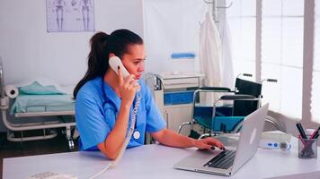 medisch receptioniste sprekend met geduldig Aan telefoon van ziekenhuis controle afspraak. Gezondheid zorg arts in geneeskunde uniform, dokter beoefenaar assistent helpen met telehealth communicatie video