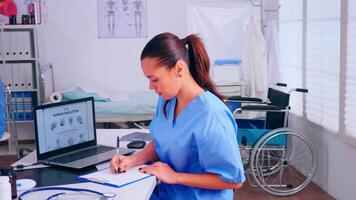 grupo de enfermeras trabajando en hospital oficina, analizando digital humano esqueleto presentación y cuerpo escanear. médico médico en medicina uniforme escritura lista de consultado, diagnosticado pacientes, haciendo investigación. video