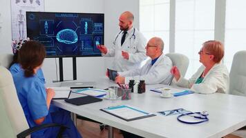 medico discutere di frenata onde mentre è indossare cuffia con sensori. tenere sotto controllo Spettacoli moderno cervello studia mentre squadra di scienziato regola il dispositivo Lavorando nel ospedale conferenza camera video