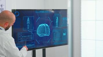 medisch mensen Holding vergadering in bestuurskamer met neuroloog dokter analyseren hersenen werkzaamheid gebruik makend van digitaal monitor. team van artsen bespreken diagnose over patiënten behandeling problemen video