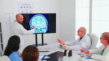 artsen pratend met specialist artsen gedurende medisch conferentie. deskundige dokter gebruik makend van modern technologie, richten Aan digitaal radiografie brainstorming met geneeskunde personeel voor expertise. video