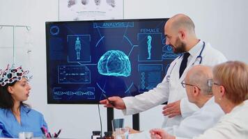 Group of specialist doctors analysing brain functions using high tech in medical boardroom, nurse testing new innovation. Medic studying diagnosis of patients working in hospital conference room video