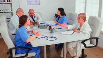 Medical expert talking with medical staff during healthcare meeting in hospital conference room explaining radiographys. Clinic therapist talking with colleagues about disease, medicine professional video