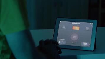 Mann mit Stimme aktiviert Clever kabellos Beleuchtung App auf Tablette drehen auf das Glühbirnen im Haus mit modern Software. Person steuern Ambiente Licht mit Zukunft Technologie, Stimme Aktivierung Befehl video