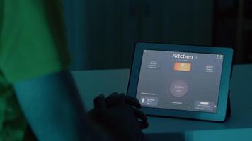 man använder sig av röst aktiverad smart trådlös belysning app på läsplatta vändning på de lökar i hus med modern programvara. person kontrollerande atmosfär ljus med framtida teknologi, röst aktivering kommando video