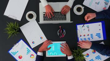 Corporate manager explaining financial reports to businesspeople, meeting shot from top view in company office. Working in team conference with project planning document on table. video