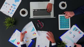 High angle view of professional business people meeting in conference room with company manager planning financial strategy using modern technology in corporate building. Copy space, flat lay concept video