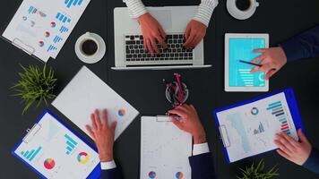 Professional partners having business conference in boardroom meeting brainstorming corporate strategy using graph statistics data above view. Top view, copy space, flat lay concept video