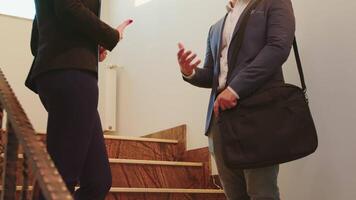 affärsman i kostym skakning händer med kvinna kollega på kontor trappa medan diskuterar i finansiera företags- företag. grupp av professionell affärsmän arbetssätt i modern finansiell arbetsplats. video