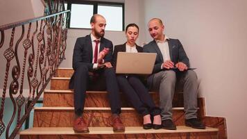 Businesswoman talking with company manager and office executive on staircase of business building. Professional entrepreneur in team work with coworker on office stairs using the laptop and tablet. video