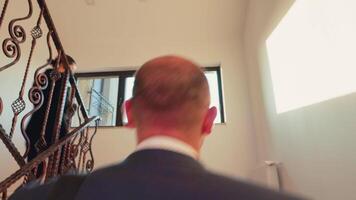 Back view of tired businessman arriving on business office walking up on stairs of finance corporate company. Group of professional successful businesspeople working in modern financial building. video