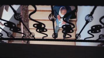 Top view of manager searching useful information on clipboard sitting on stair in corporate business building. Overworked tired businessman at workplace analysing deadline for job project. video