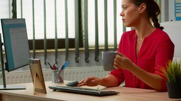 pigiste en buvant café à le Bureau et dactylographie à ordinateur dans spécial programme. entrepreneur travail dans moderne professionnel espace de travail lieu de travail dans entreprise entreprise avec sans fil ordinateur clavier video