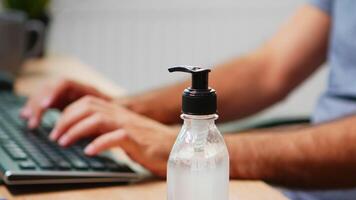 Close up of man using hand sanitizer sanitiser while working in office room. Entrepreneur in new normal company office workplace cleaning disinfecting hands using alcohol gel against corona virus. video