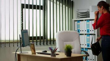 Young business woman comming at work early in the morning. Entrepreneur working in modern professional office, workplace in personal corporate company typing on computer keyboard looking at desktop video