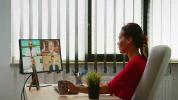företag kvinna diskuterar på webbkamera med partners Sammanträde i modern kontor. frilansare arbetssätt med avlägset team chattar har virtuell uppkopplad konferens, möte, webinar använder sig av internet teknologi video