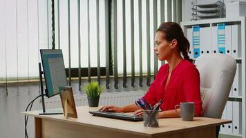 Business woman typing on computer in modern office room. Hispanic entrepreneur working in professional workspace workplace in personal corporate company writing on computer keyboard looking at desktop video